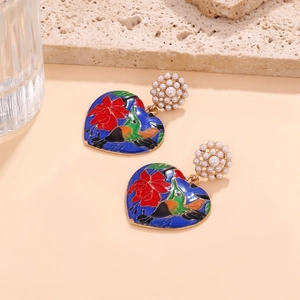 Detail of enamel heart earrings featuring kingfisher and floral motifs with pearl accents