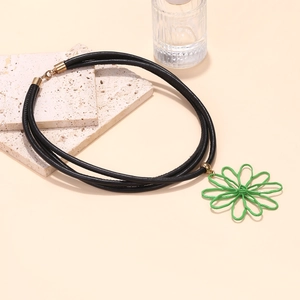 Détail du collier multi-rangs en PU noir avec pendentif fleur verte et fermoir doré