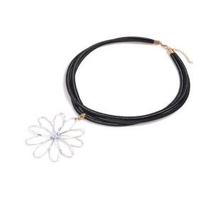 Détail du collier à cordons noirs multiples avec un pendentif fleur en fil blanc