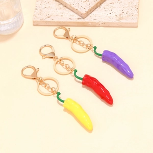 Detail view of three 3D resin chili pendants in red, purple, and yellow with gold clasps