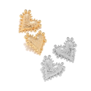 Detailed view of heart-shaped earrings with hammered texture and beaded edges