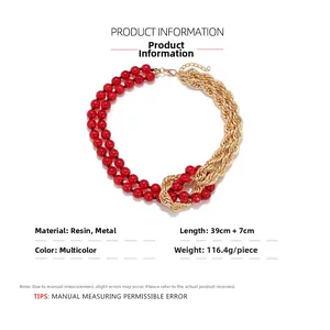 Detail of bohemian necklace with red resin beads and golden metal chain link design