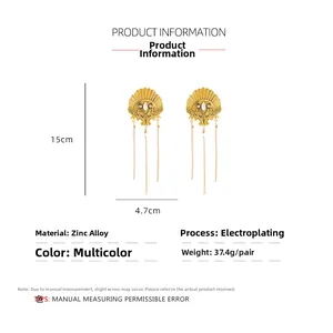Détail de boucles d'oreilles éventail dorées en alliage de zinc avec mesures de 15 cm