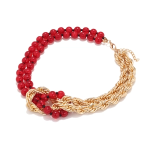 Vintage necklace with red beads and layered gold chains featuring a central knotted design