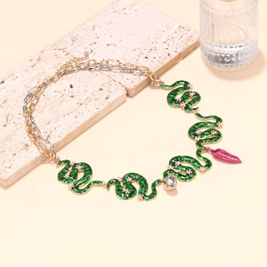 Detailed shot of green enamel snake links with pink leaf and silver ball pendants