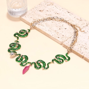 Detail of green enamel snake links with pink floral accents on mixed metal chain