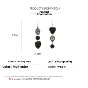 Detailed view of asymmetric heart drop earrings showing size dimensions 8.8cm by 2.3cm