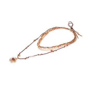 Multi-layer necklace with amber beads and golden pomegranate flower pendant on white background