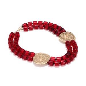 Detail of double-layer dark red beaded necklace with vintage gold floral relief pendants