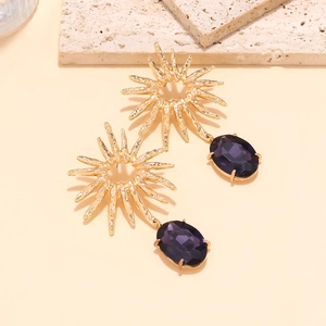 Vintage gold sunflower drop earrings with purple crystal pendants on stone background