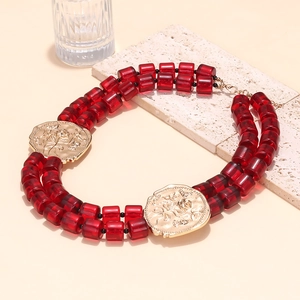 Close-up of bohemian double-layered red beaded necklace with vintage gold floral medallions