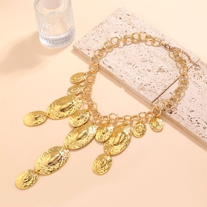 Gros plan d'un collier chaîne doré avec pendentifs ovales irréguliers martelés