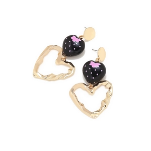 Detailed close-up of gold dangling earrings with strawberry charms and heart pendants
