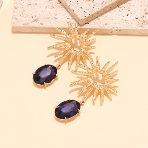 Close-up of vintage sunburst drop earrings with large purple oval faceted crystals