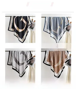 Macro detail of twill silk scarves with monogram letter G patterns in four color variants