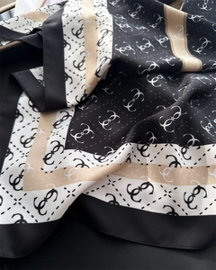 Detailed view of silk satin scarf with elegant letter print and fine hemmed edges