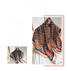Detail of floral and geometric print silk scarf in burgundy and black tones