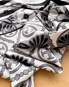 Detailed macro shot of a black and white twill scarf featuring elegant floral patterns