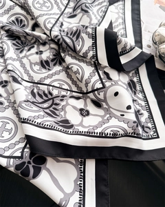 Detail of silk-texture square scarf with geometric floral patterns and elegant draping