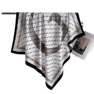 Elegant black and white printed silk scarf with classic interlocking patterns and black border