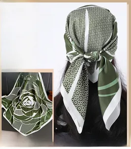 Détail d'un foulard en soie avec motif de roses vert herbe et bordures géométriques