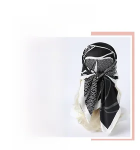 Détail de roses réalistes et motifs géométriques sur un foulard carré en soie noir et blanc