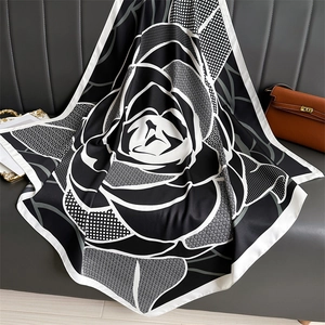 Gros plan d'un élégant foulard en soie à imprimé rose noir et blanc sur cuir