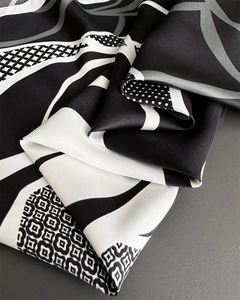 Gros plan d'un foulard en soie à motifs géométriques avec texture sergée et coutures