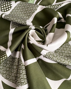 Détail de la texture sergé d'un foulard en soie verte avec motifs géométriques et points