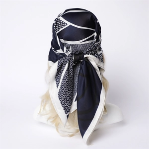 Détail d'un foulard en soie imprimé géométrique bleu et blanc noué sur un mannequin