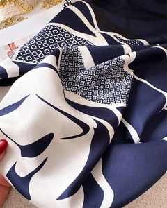 Détail de la texture soie et des motifs géométriques marine sur le foulard carré