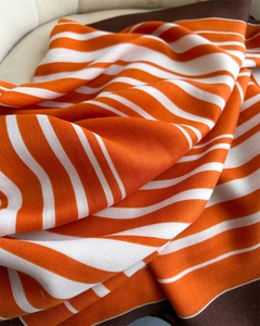 Detail of orange and white striped scarf showing premium herringbone weave texture
