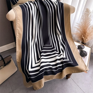 Detail of silk-like scarf with black and white stripes and a wide camel border