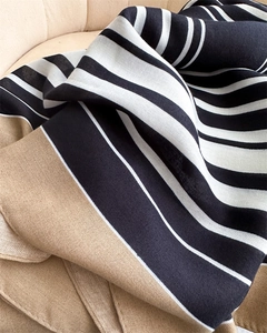 Macro shot of herringbone weave detail on black, white and camel striped scarf
