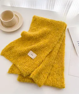 Detail of soft yellow knit scarf with fluffy mohair texture and minimalist ins tag