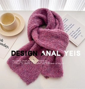 Detailed texture of purple bouclé knit scarf with minimalist ins woven label on table