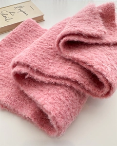 Close-up of soft pink bouclé wool scarf showing fluffy texture and thick knit layers
