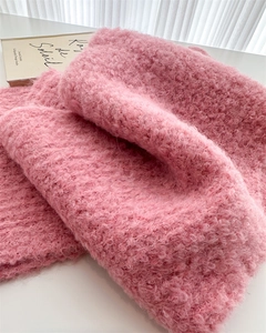 Close-up of thick pink chunky knit wool scarf showing soft textured loop yarn material