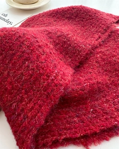 Close-up of soft red chunky knit wool scarf with a fluffy boucle texture for winter