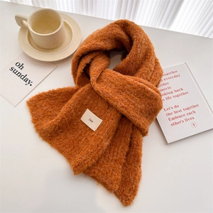 Minimalist orange knit wool scarf with ins-style label on a cozy cafe lifestyle background