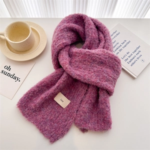 Detailed texture of purple melange knit scarf with ins woven label on white table