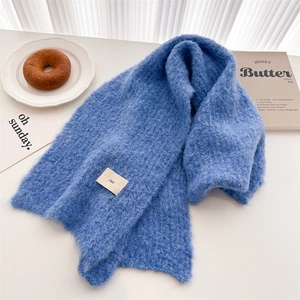 Detail of soft blue wool knit scarf with ins label and cozy home lifestyle items