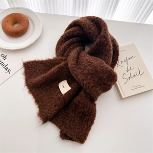 Detail of dark brown wool knit scarf with soft curly texture and minimalist ins tag
