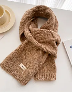 Close-up of thick cable knit wool scarf in camel brown with stylish fringe edge