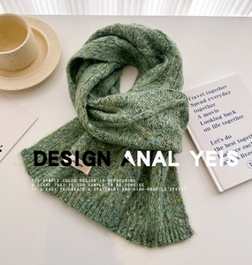 Detailed close-up of grass green cable knit wool scarf with soft texture and colorful flecks