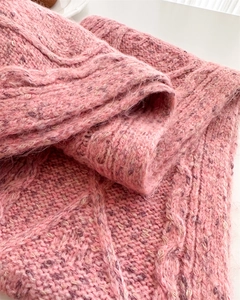 Macro detail of pink chunky cable knit wool texture with soft mohair fiber finish