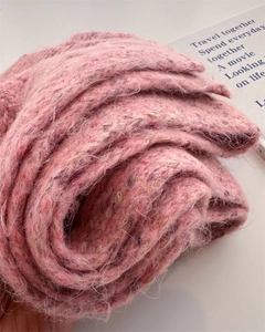 Detail shot of pink wool knit scarf showing plush texture and soft variegated yarn
