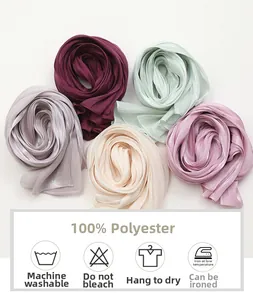 Close-up of five colorful solid polyester scarves rolled in a floral pattern