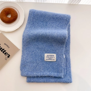 Royal blue wool knit scarf with soft fluffy texture and minimalist brand label on white back