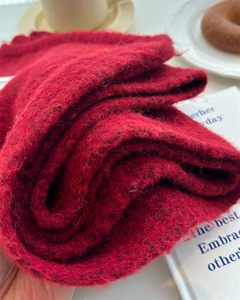 Close-up of fluffy red knit wool scarf texture in a cozy winter lifestyle setting